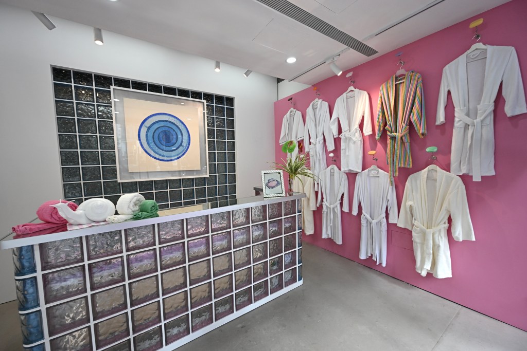 在油街玻璃屋地下入口處，陳惠立設置了一個浴場接待處，牆上掛滿了浴袍及繪畫新作。